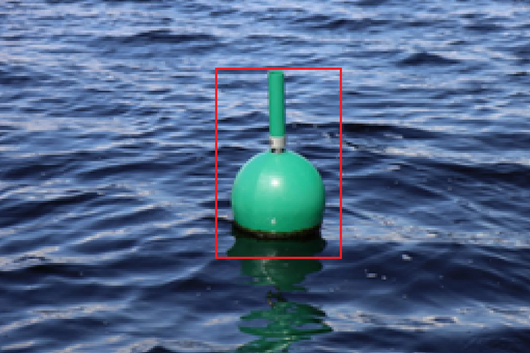 Camera image of a green buoy on open water with a detection bounding box