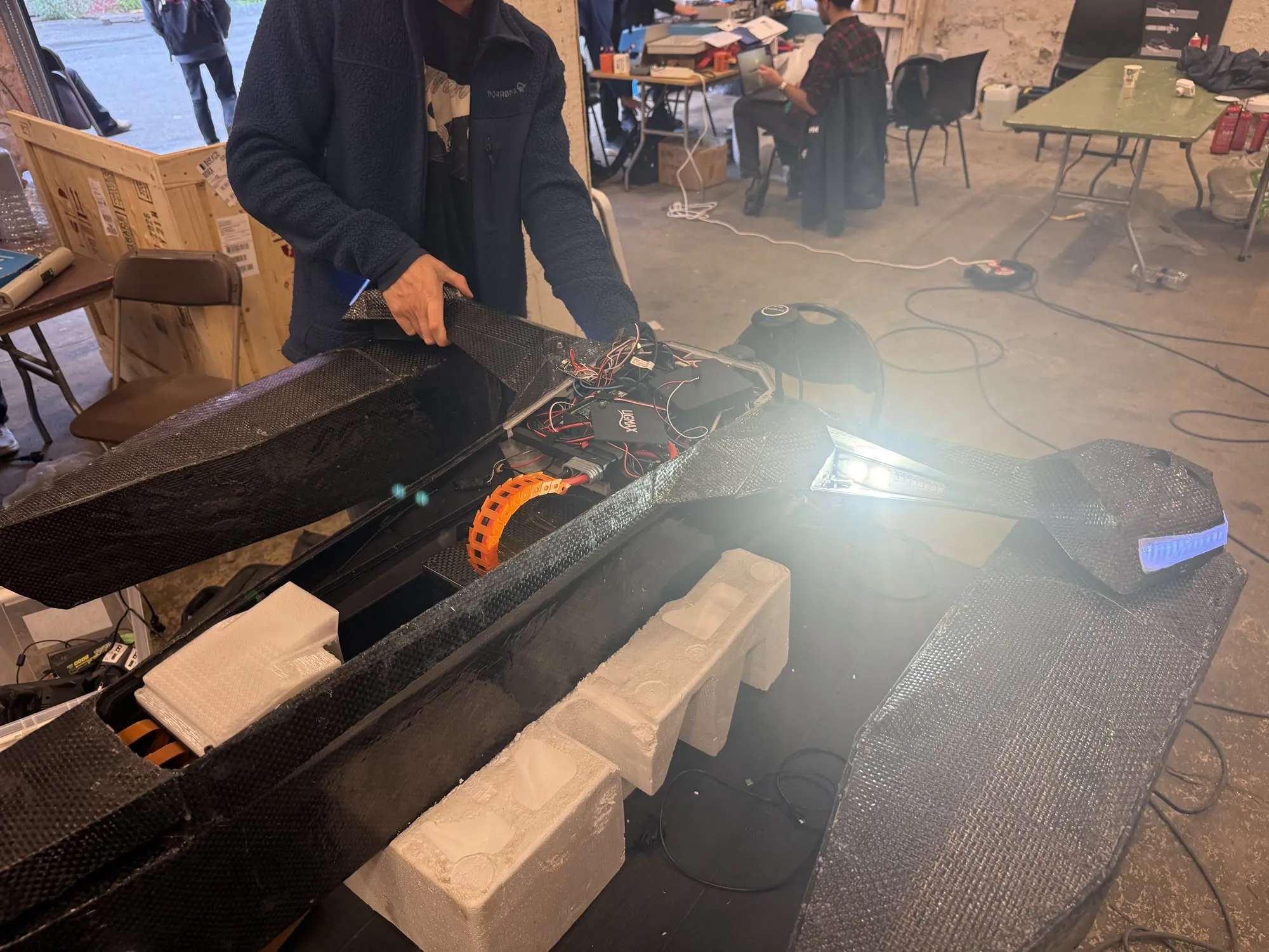 The forward-facing pop-up lights on the Ligmax hull opened and lit inside the workshop